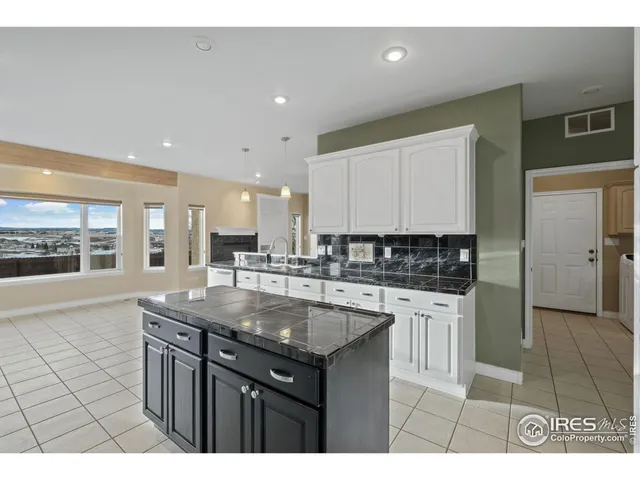 a kitchen with kitchen island granite countertop a sink and cabinets