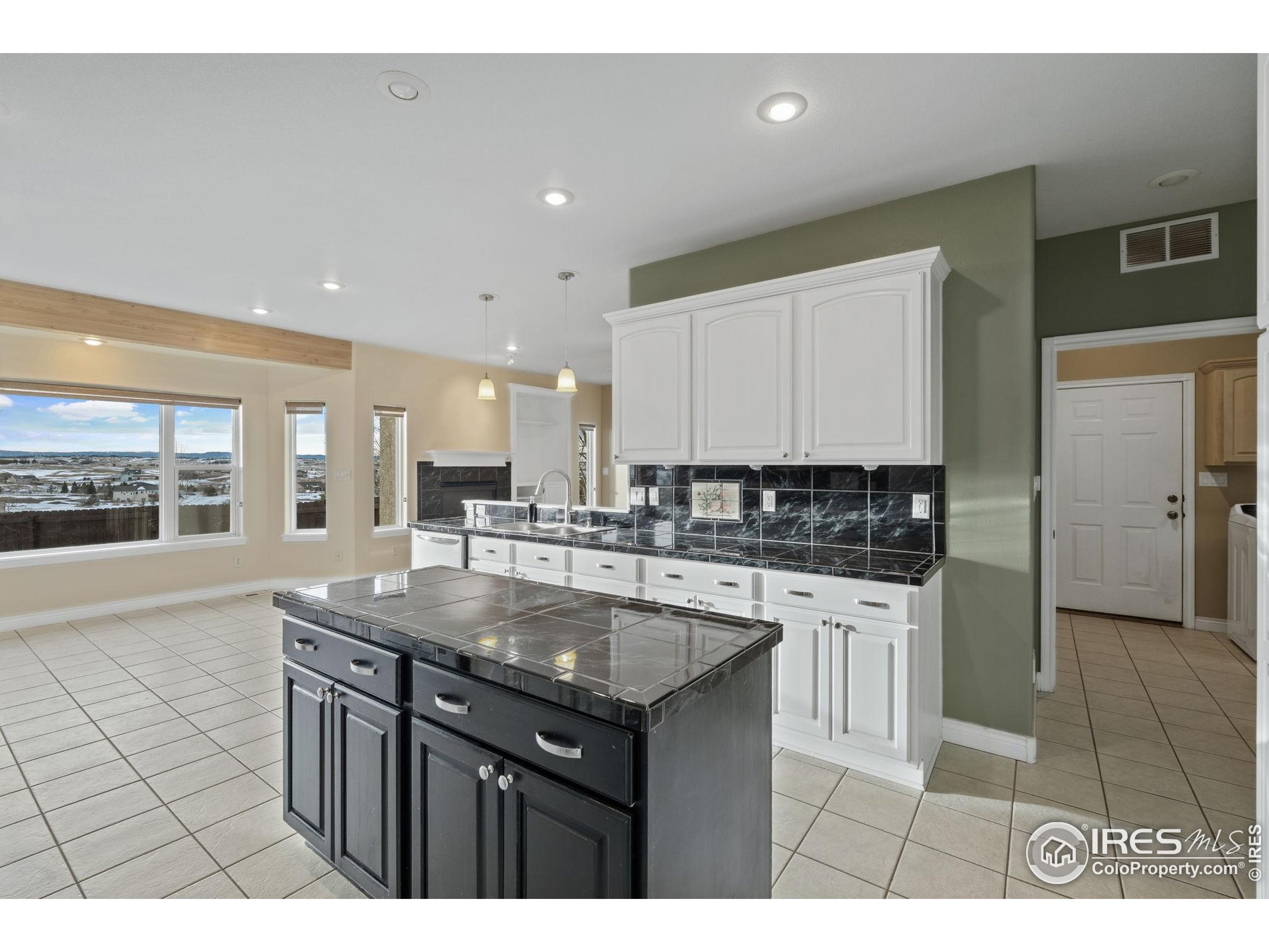 17035 Herring Road Colorado Springs, CO 80908 - Photo 16 of 38 a kitchen with kitchen island granite countertop a sink and cabinets