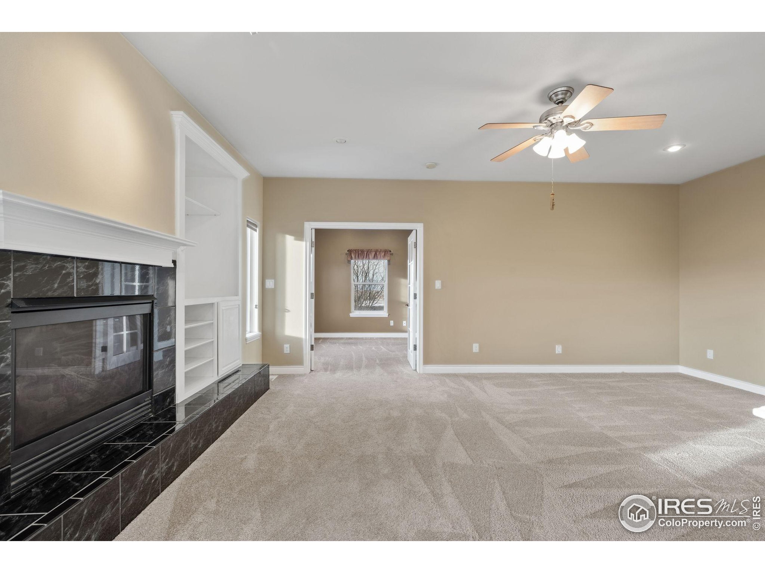 17035 Herring Road Colorado Springs, CO 80908 - Photo 19 of 38 a view of an empty room with a fireplace and a window