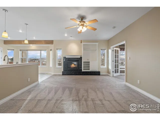 a view of an empty room with a kitchen and a window
