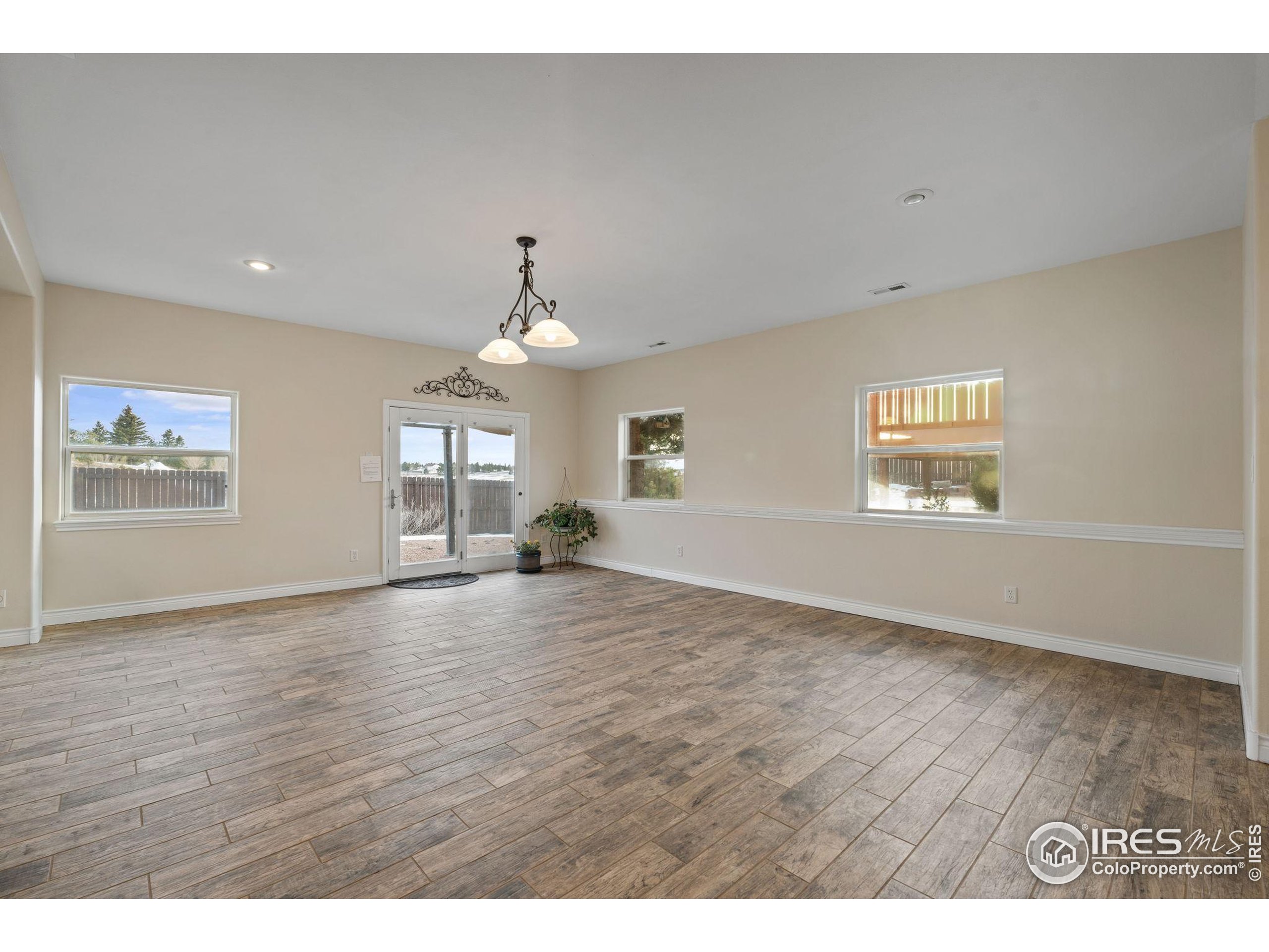 17035 Herring Road Colorado Springs, CO 80908 - Photo 32 of 38 a view of empty room with wooden floor and fan