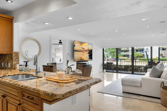 a living room with granite countertop couches a coffee table and a flat screen tv
