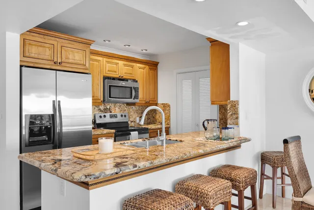 a kitchen with stainless steel appliances granite countertop a refrigerator and a sink