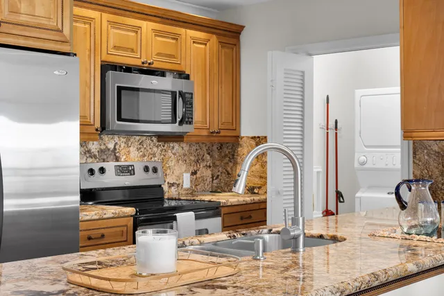 a kitchen with stainless steel appliances granite countertop a refrigerator and a sink