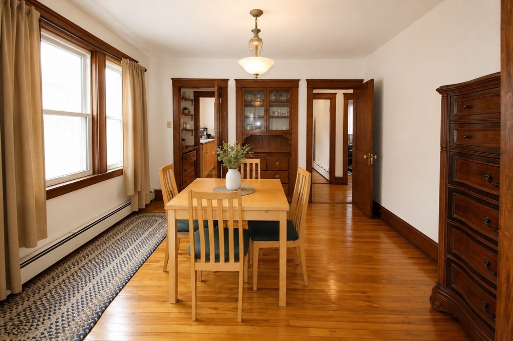 15 Herbert Road, Unit 15 Arlington, MA 02474 - Photo 5 of 9 a dining room with wooden floor a chandelier a glass table and chairs