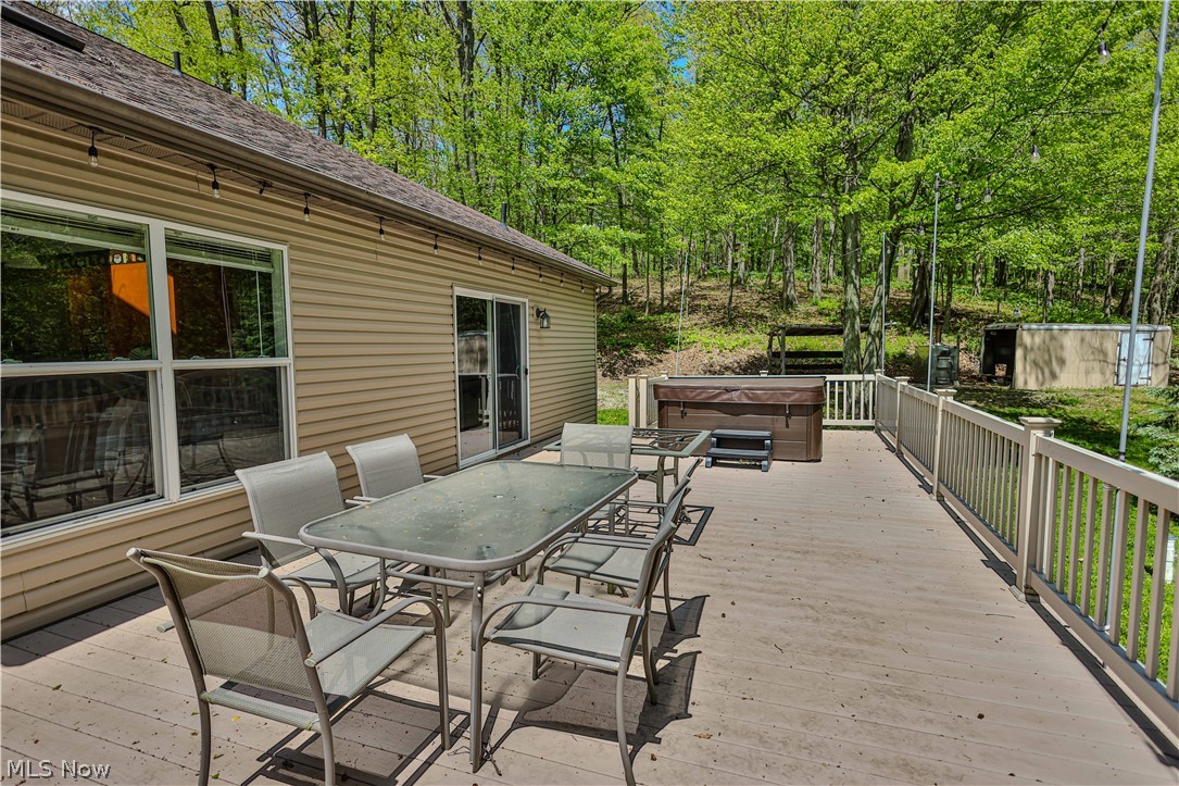 11154 Johnsford Road Southwest Beach City, OH 44608 - Photo 10 of 50 Spacious outdoor deck featuring composite decking and white railing, sliding glass door access, and a built-in hot tub