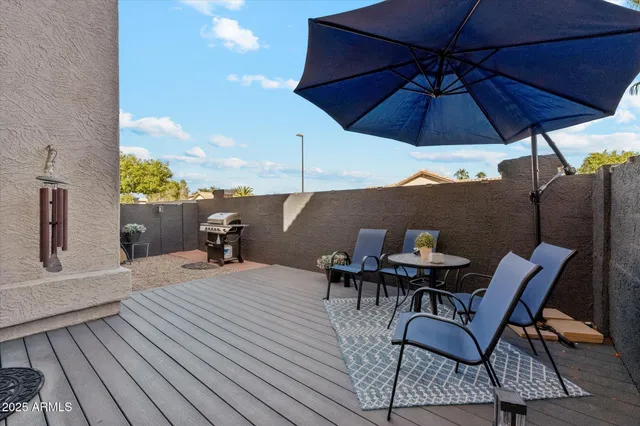 a view of a roof deck with table and chairs under an umbrella