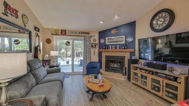 a living room with furniture a flat screen tv and a fireplace
