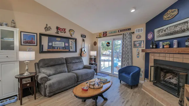 a living room with furniture a flat screen tv and a fireplace