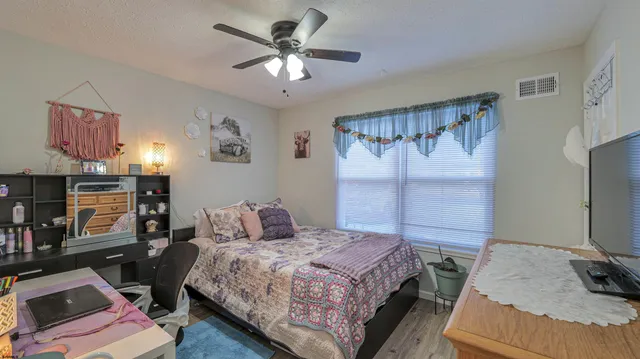 a bedroom with a bed window and a flat screen tv