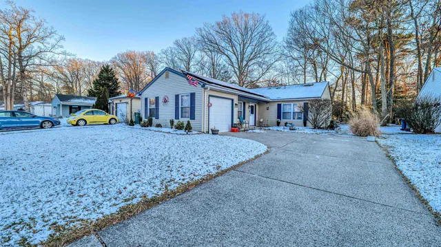 a view of a house with a yard and large tree