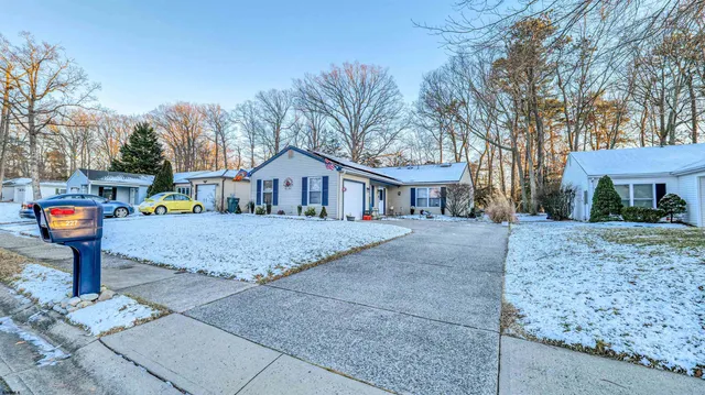 a front view of a house with a yard and tree s