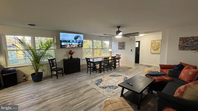 a living room with furniture a dining table and a large window