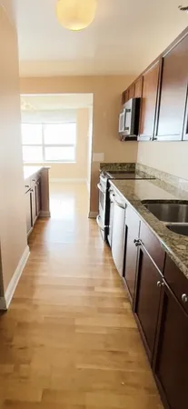 a kitchen with granite countertop a sink and a stove top oven