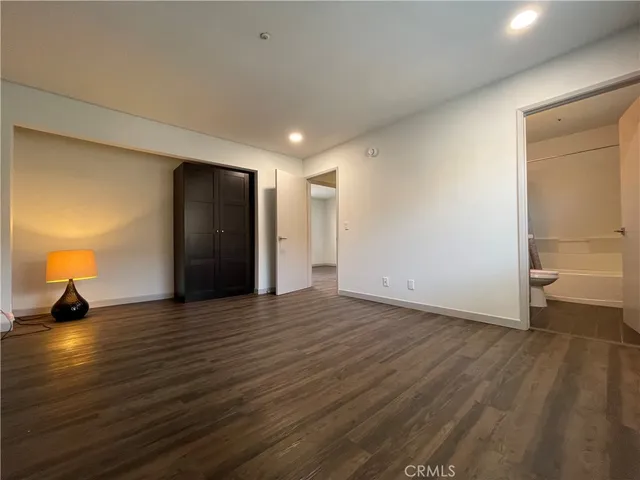 a view of empty room with wooden floor and window