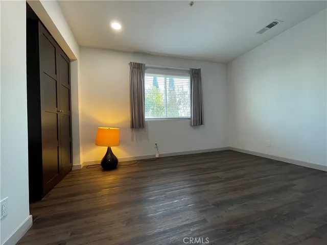 an empty room with wooden floor and a window