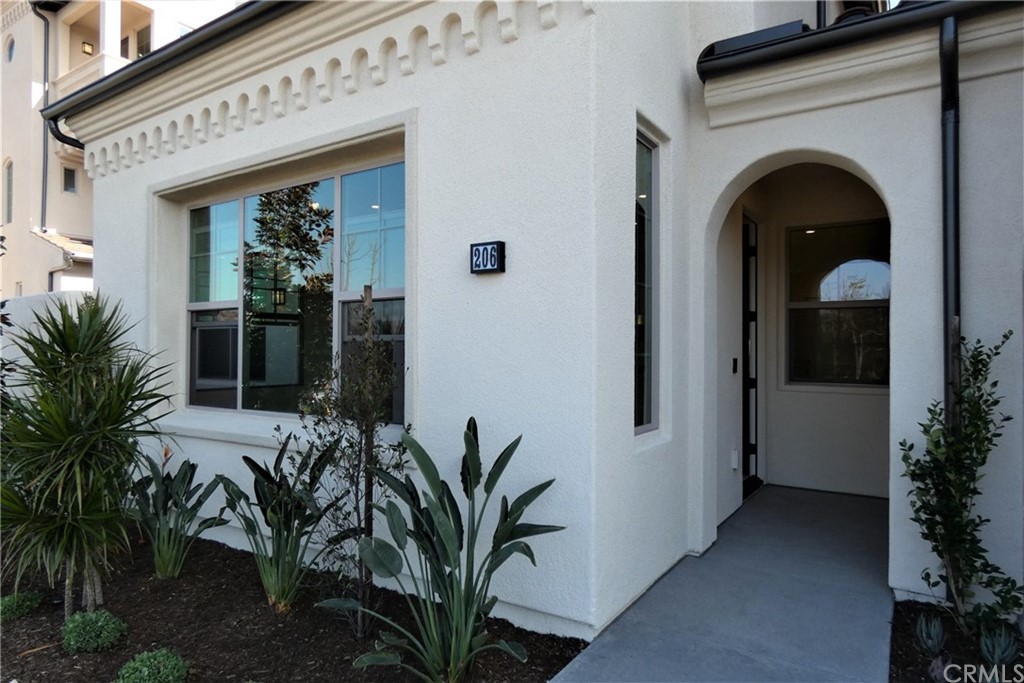 206 Oak Forest Irvine, CA 92618 - Photo 5 of 42 a view of a house with potted plants and a table of it