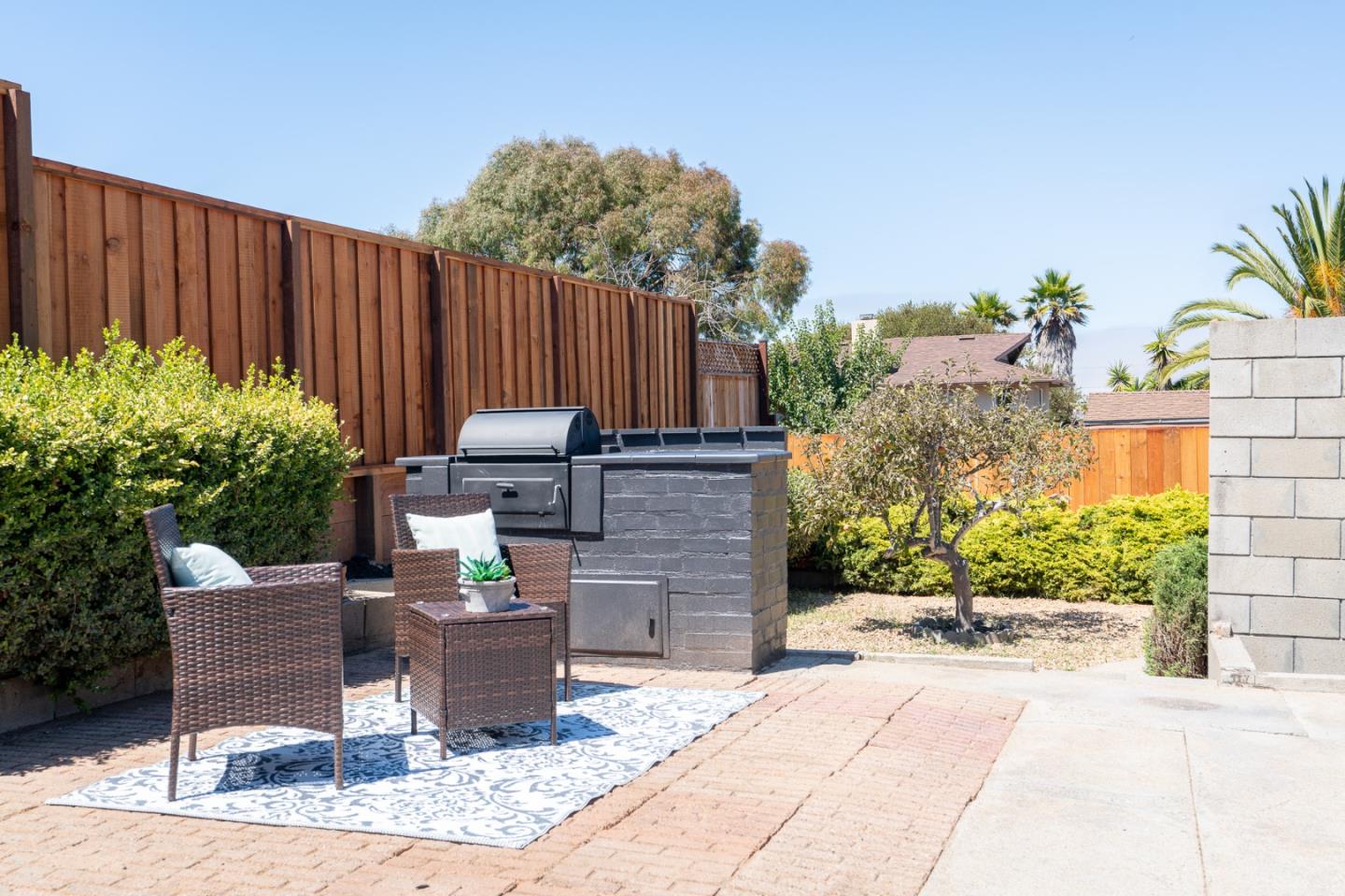 1055 Tweed Street Seaside, CA 93955 - Photo 20 of 33 a view of a patio with table and chairs potted plants and wooden fence