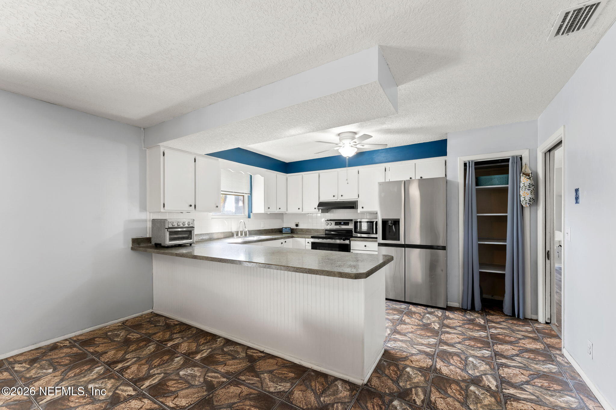 284 Baisden Road Jacksonville, FL 32218 - Photo 31 of 39 a kitchen with stainless steel appliances a sink a stove a refrigerator cabinets and a window