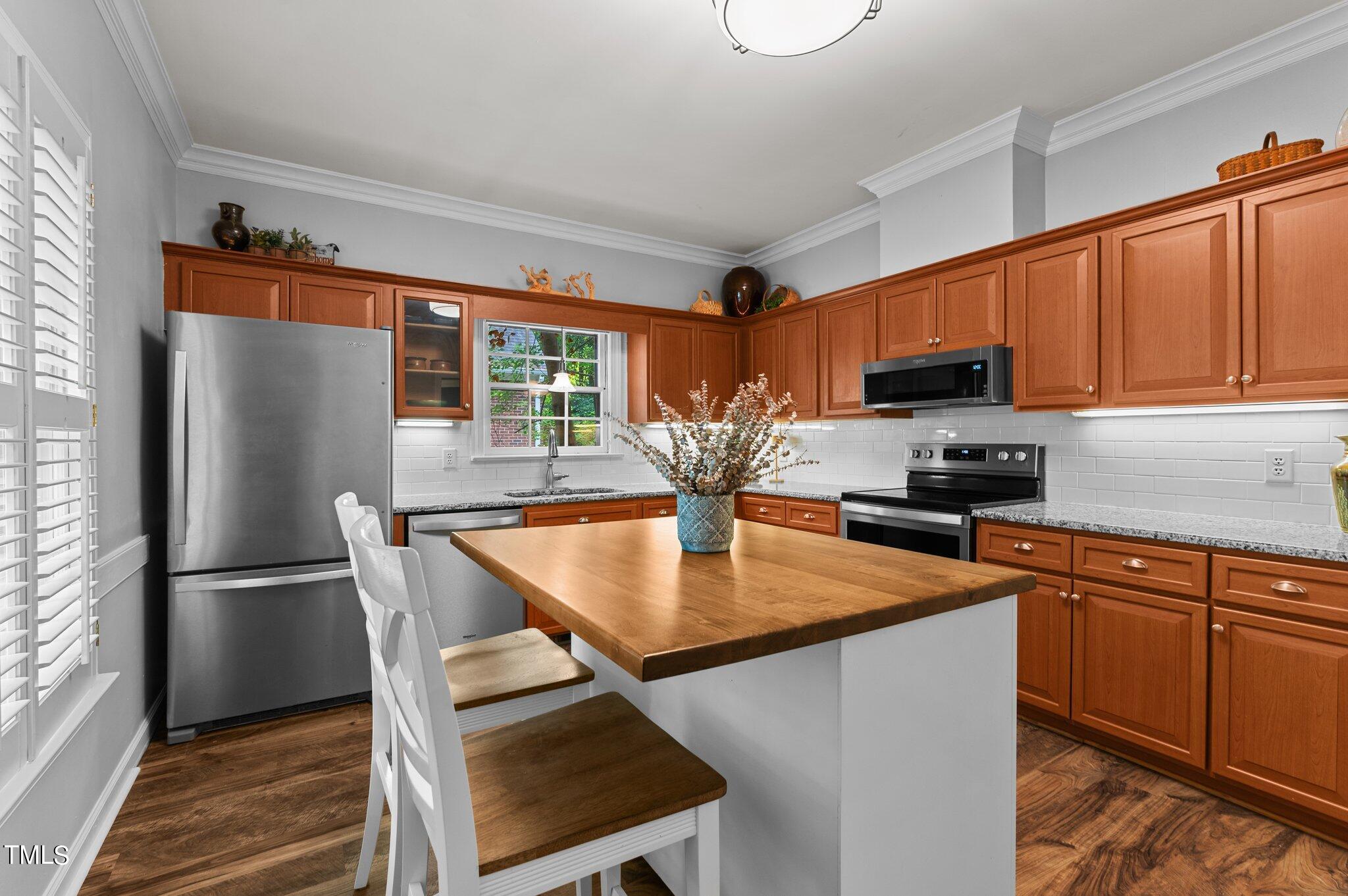 736 Weathergreen Drive Raleigh, NC 27615 - Photo 6 of 43 a kitchen with kitchen island a counter top space appliances and a refrigerator