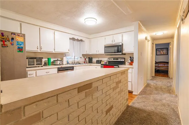 a kitchen with stainless steel appliances a refrigerator sink and microwave