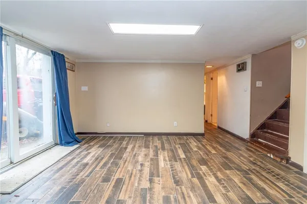 a view of a room with wooden floor and window