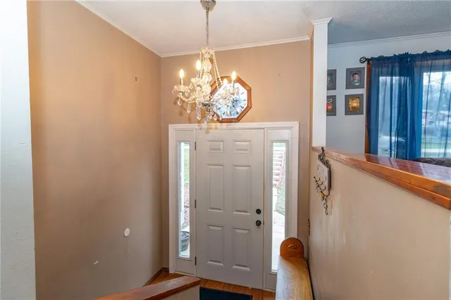 a view of a hallway with windows and chandelier