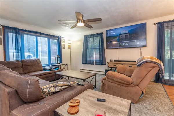 a living room with furniture ceiling fan and a window