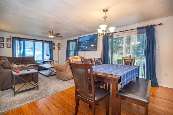 a dining room with furniture a chandelier and wooden floor