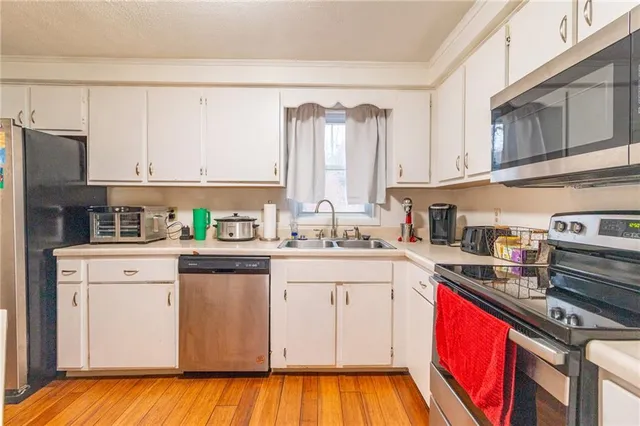 a kitchen with stainless steel appliances granite countertop a stove a sink dishwasher and a refrigerator