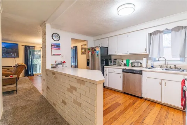 a kitchen with cabinets and wooden floor