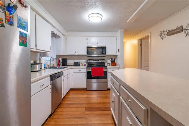 a kitchen with kitchen island a stove sink and cabinets