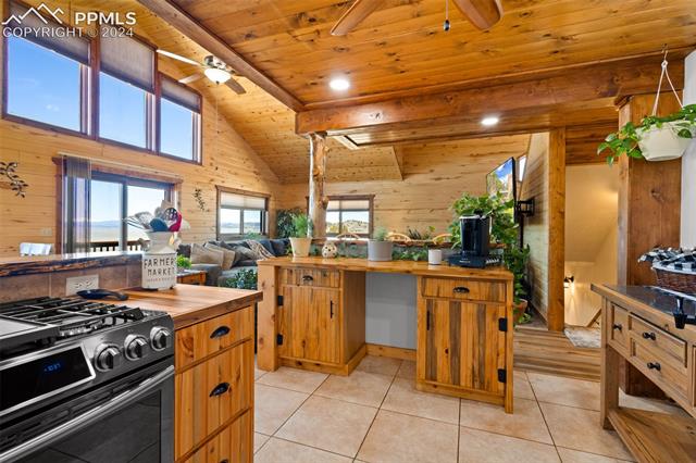 211 Yarnell Road Lake George, CO 80827 - Photo 7 of 50 Kitchen featuring light tile floors, black gas range oven, ceiling fan, and wood ceiling
