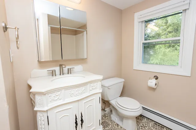 a bathroom with a sink toilet and a mirror