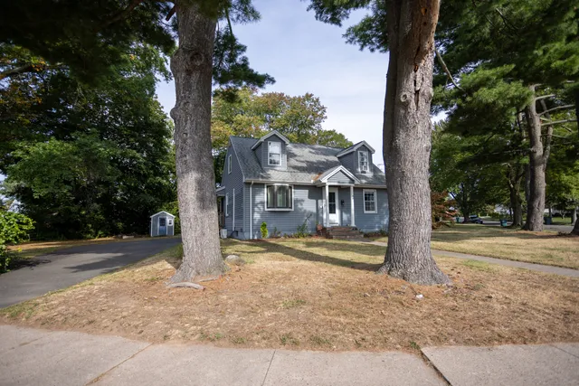 a front view of house with yard and trees around