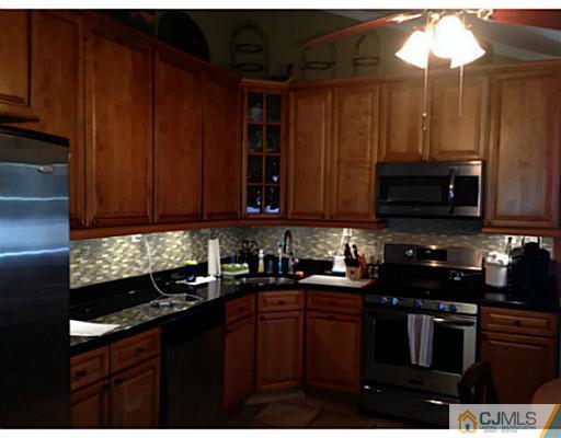21 Albemarle Road Colonia, NJ 07067 - Photo 4 of 22 a kitchen with stainless steel appliances wooden cabinets and a sink