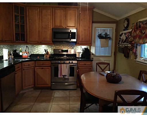 21 Albemarle Road Colonia, NJ 07067 - Photo 5 of 22 a kitchen with stainless steel appliances a stove a sink a microwave a refrigerator and cabinets