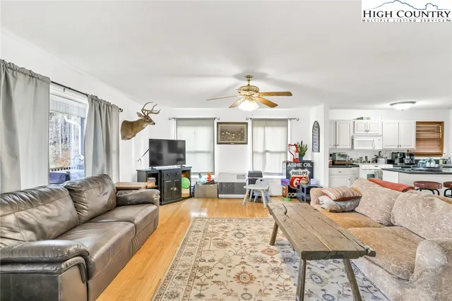 a kitchen with stainless steel appliances kitchen island granite countertop a stove a sink dishwasher and a refrigerator with wooden floor