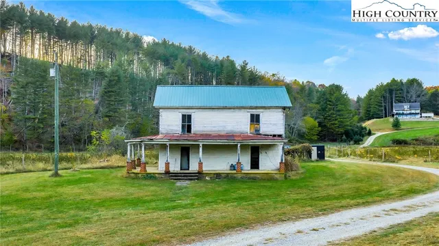 a view of swimming pool with lawn chairs and large trees