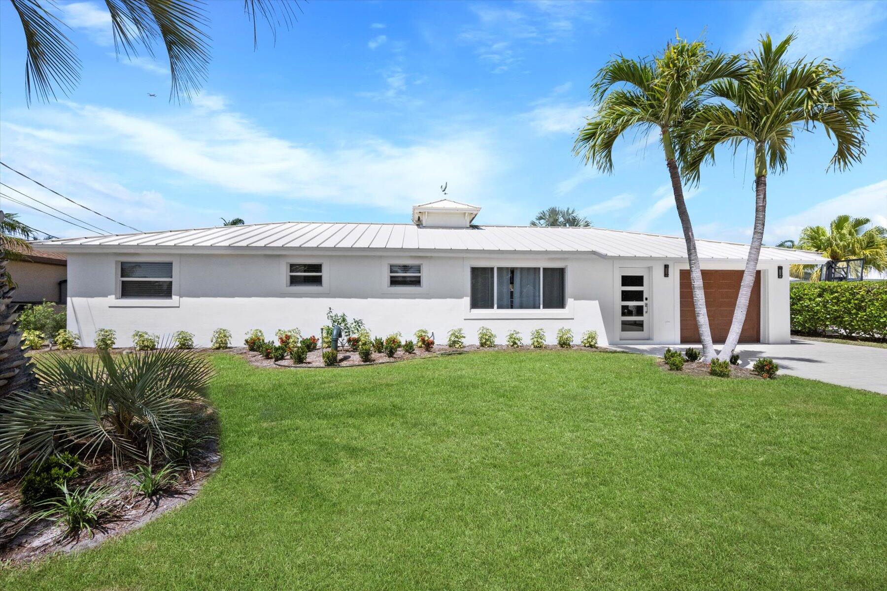 1389 Southwest Dyer Point Road Palm City, FL 34990 - Photo 3 of 55 a front view of a house with a garden