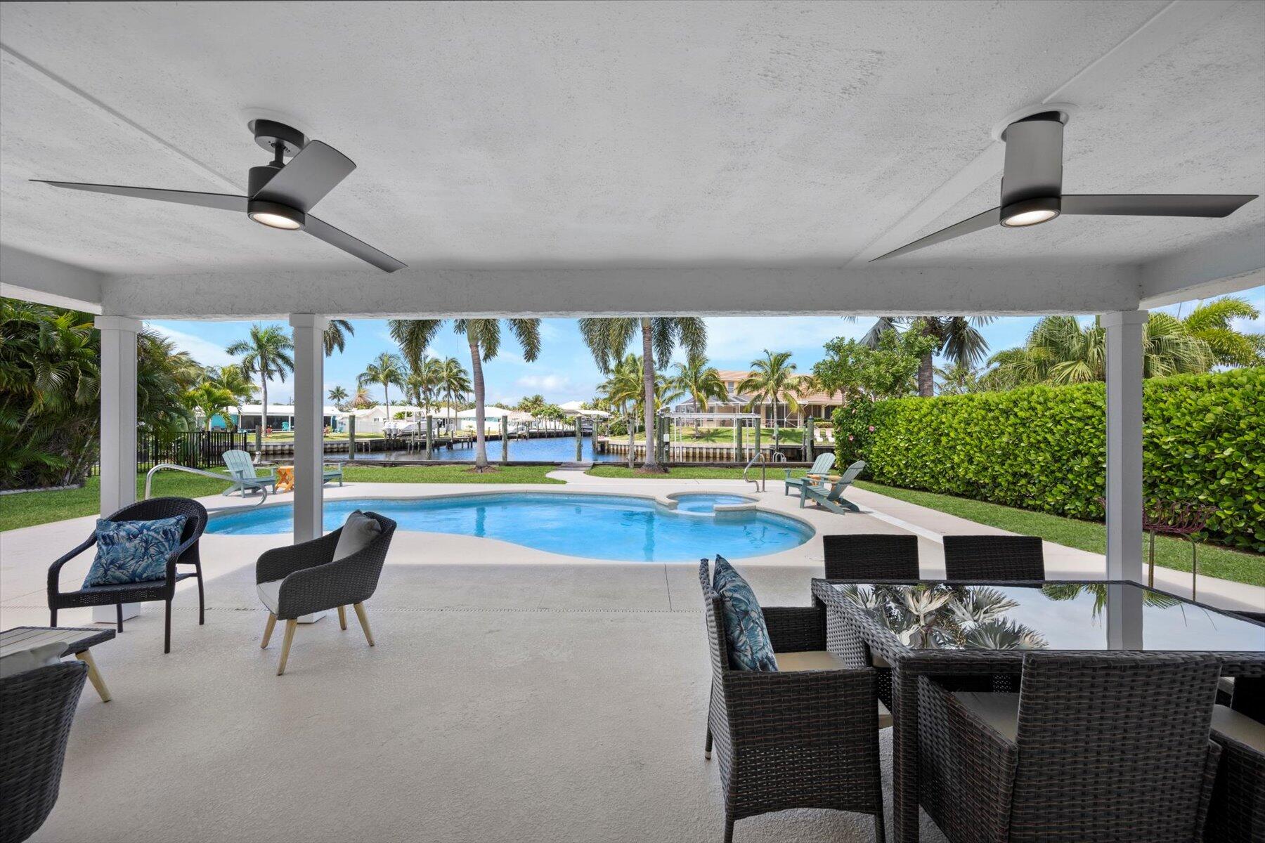 1389 Southwest Dyer Point Road Palm City, FL 34990 - Photo 8 of 55 a view of a patio with a dining table chairs and a floor to ceiling window
