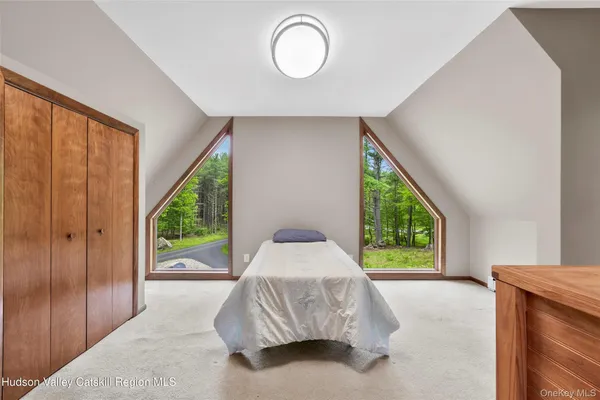 a bedroom with a bed and a large window
