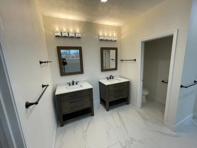 a bathroom with a double vanity sink a mirror and bathtub