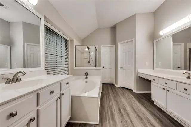 a spacious bathroom with a double vanity sink a mirror and a bathtub