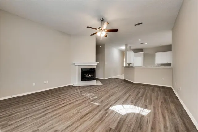 a view of empty room with wooden floor and fireplace