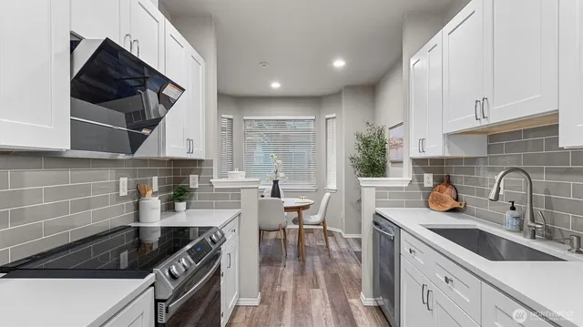 a kitchen with stainless steel appliances a sink a stove and cabinets