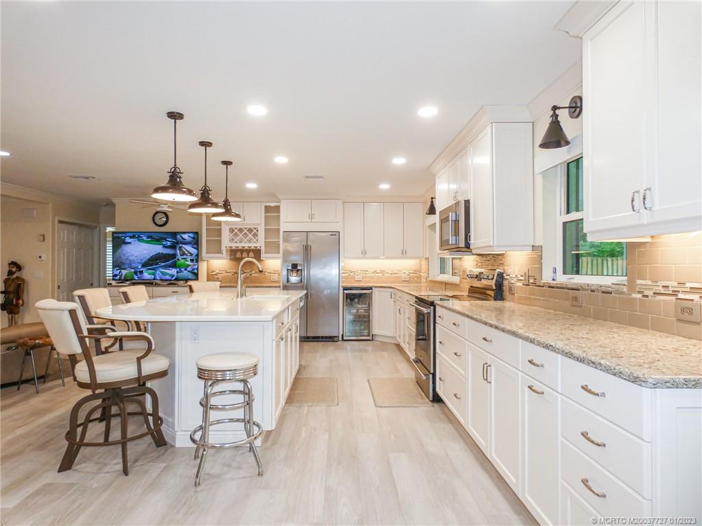 308 Southwest Ridge Lane Stuart, FL 34994 - Photo 12 of 43 a kitchen with stainless steel appliances kitchen island granite countertop a sink and cabinets
