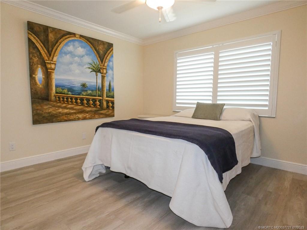 308 Southwest Ridge Lane Stuart, FL 34994 - Photo 25 of 43 a bedroom with a bed and a painting on the wall