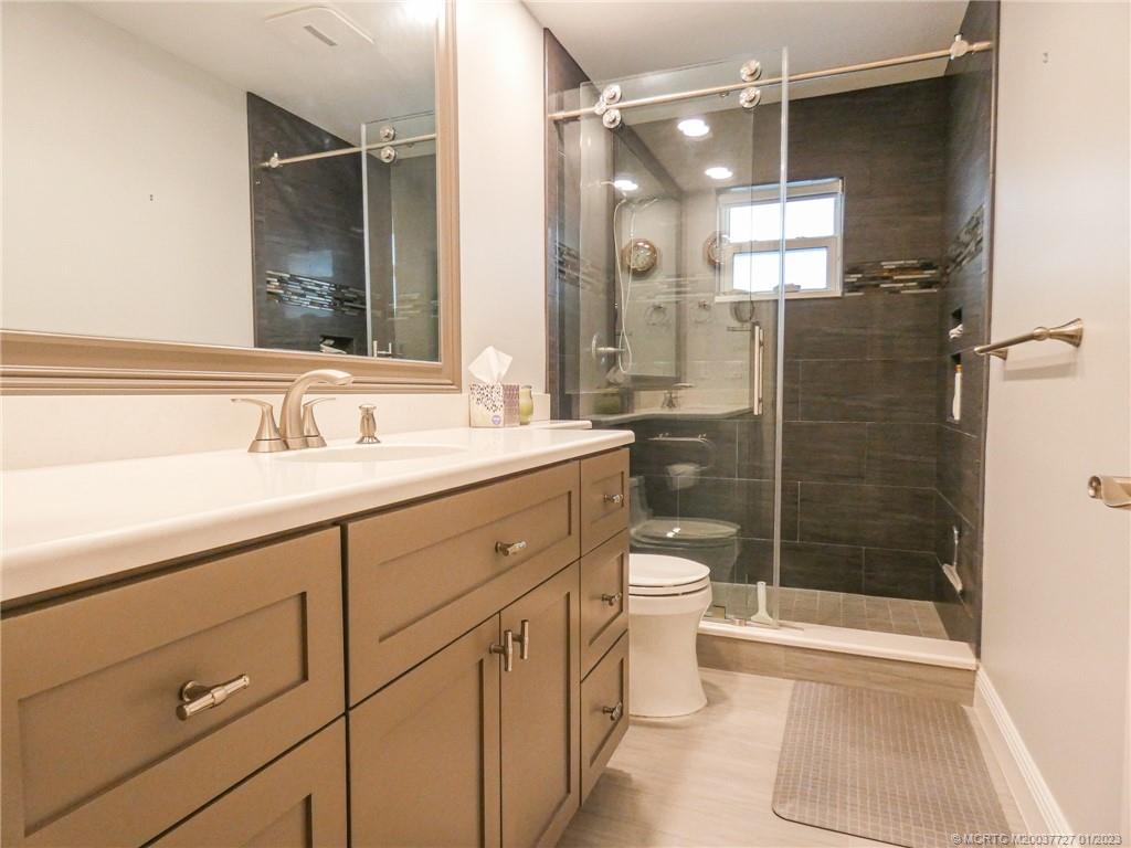 308 Southwest Ridge Lane Stuart, FL 34994 - Photo 27 of 43 a bathroom with a shower sink vanity mirror and toilet