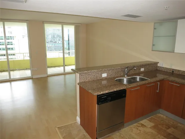 a view of kitchen with stainless steel appliances granite countertop a refrigerator and a sink